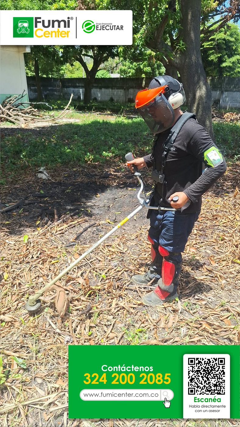 Operario de FumiCenter con guadaña, careta y protector auditivo cortando maleza en Santa Marta
